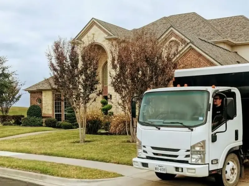 Junk removal truck parked outside a brick home