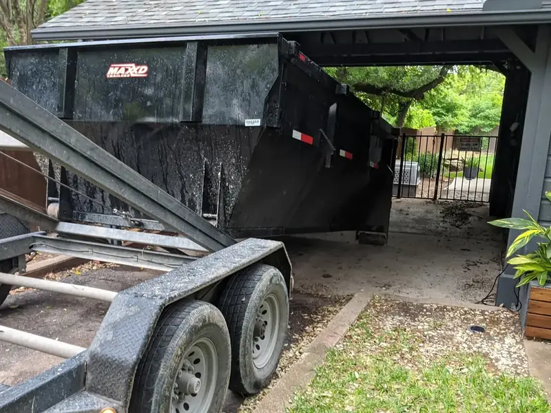 Dumpster trailer parked at a carport for a cleanout
