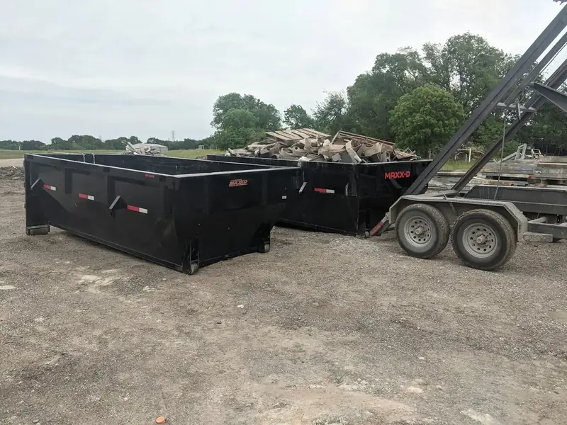 Two empty roll-off dumpsters ready for delivery